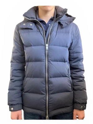 Marinblå J.Lindeberg jacka - Snygg mörkblå dunjacka med huva och dragkedja framtill från J.lindeberg. Jackan har quiltad design, två sidofickor med dragkedja och hög krage. Perfekt för kalla vinterdagar och ger en stilren look. Den här många fina detaljer runt fickorna/huvan. Jätte snyggt J.lindeberg märke på ena armen. Jackan är sällsynt och säljs inte mer. Nypris är runt 5000kr.🤩🤩