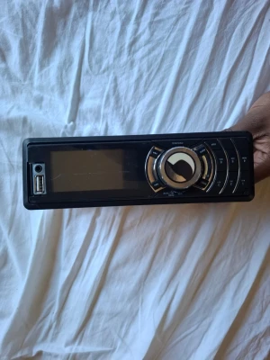 Biltema stereo - Snygg bilradio i svart och silver med stor rund volymratt och USB-port på framsidan. Displayen är bred och knapparna är placerade runt ratten för enkel styrning. Metallhölje på baksidan. Perfekt för dig som vill uppgradera ljudsystemet i bilen.