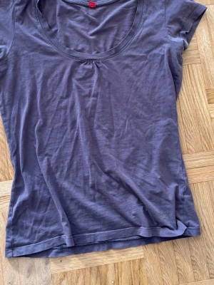 Brun enkel topp från RT - En basic brun topp från RT med rund halsringning och korta ärmar. Tillverkad i mjuk bomull som känns skön mot huden. Perfekt att matcha med jeans eller kjol för en clean look.