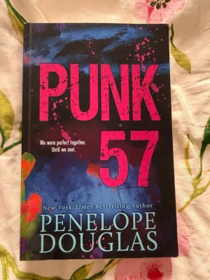 Punk 57 av Penelope Douglas 18+ - Punk 57 är en ungdomsroman med svart omslag och stora rosa bokstäver. Boken handlar om Misha och Ryen, två tonåringar som brevväxlar och upptäcker varandra på oväntade sätt. Perfekt för dig som gillar romantik och drama med en modern twist. 18+