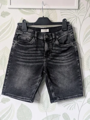Jeansshorts Staffan Lindex Storlek 152 - - Jättemjuka och elastiska jeansshorts.  - Använd en gång så i nyskick jag hittar inget att anmärka på mer att det finns ett litet skavmärke i bakbenet.  - Jag kan ha missat någon miniskavank men jag har försökt att granska plagget så gott det gårr