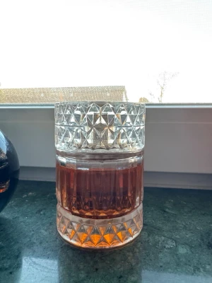 Sharaf Blend parfym i glasburk - Sharaf Blend parfym i en elegant, rund glasburk med slipat mönster och guldfärgat lock. Parfymen har en djup bärnstensfärgad ton och burken ger en lyxig känsla. Perfekt för dig som gillar exklusiva dofter och snygg design på parfymflaskan.