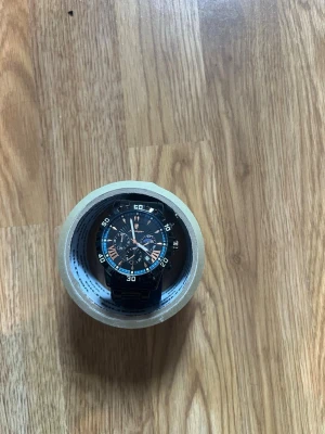 Svart sportig klocka med blå detaljer - Snygg och sportig klocka från Naviforce med svart metallarmband och blå detaljer på urtavlan. Klockan har flera små urtavlor, tydliga siffror och robust design. Perfekt accessoar för dig som gillar en modern och stilren look.