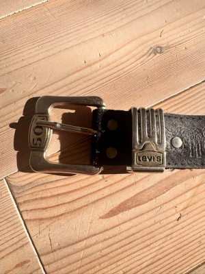 Vintage Levi’s bälte  - Svart skärp från Levi's i skinn med robust metallspänne och detaljer i guld och silver. Kom gärna med bud!