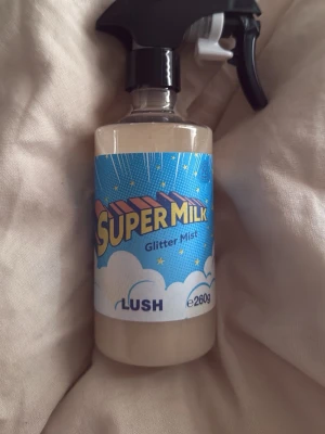 Lush Super Milk Glitter Mist 260g - Super Milk Glitter Mist från Lush. Kan användas till både kropp och hår. Doftar som en citronbakelse. Perfekt för dig som vill ge håret extra glans och mjukhet. Volymen är 260g. Endast testad 