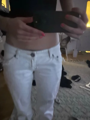 Vita raka jeans med låg midja - Säljer ett par vita jeans med låg midja och utsvängda ben. Dom är ifrån River Island. Midjemått är 39cm och innerbenslängden är 80cm💞💞