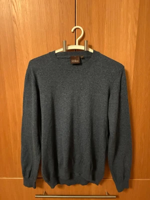 Oscar Jacobson tröja  - Riktigt snygg tröja från Oscar Jacobson. Väldigt snygg blå/grå färg i 100% cotton. Säljs pga att jag ska köpa AirPods Max och därmed behöver pengar alltså inget fel på tröjan