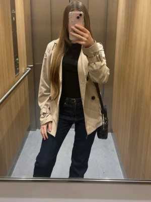 Mörkblå bootcut jeans - Säljer ett par mörkblå bootcut jeans med klassisk femficksdesign och medellågmidja. Jeansen har raka ben och är tillverkade i ett stretchigt denimtyg som sitter snyggt. Perfekta för en avslappnad men ändå stilren look.