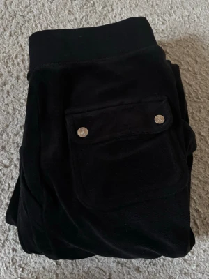 Svarta Juicy Couture  - Svarta mjukisbyxor från Juicy Couture. Bra skick förutom att metall grejerna på snöret har lossnat men annars bra skick.