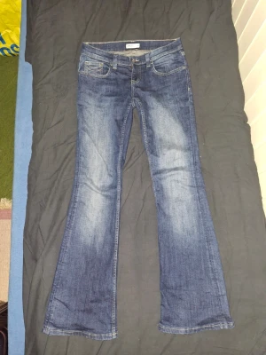 Mörkblå bootcut jeans  - Säljer ett par klassiska mörkblå bootcut jeans. Jeansen e low waist och har en fin söm på bakfickorna och även fickor där fram. Använda cirka 2-3 gånger.
