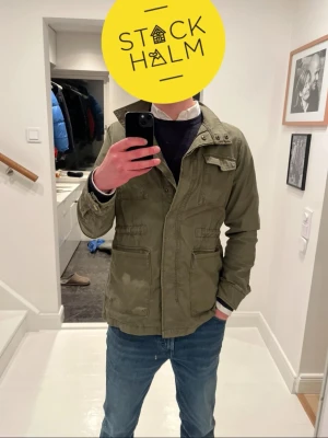Field jacket - En trevlig field jacket i färgen oliv grön vilket är den bästa jack färgen enligt mig, mycket fickor och relativt varm perfekt vår/sommarnatts jacka. Storlek S. Inga tecken på användning                                               Priset är inte fast kom med bud om du är intresserad!