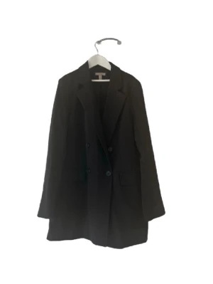 Svart oversized kavaj från H&M🌸 - Stilren svart oversized kavaj från H&M med dubbelknäppning och klassiska slag. Kavajen har två fickor framtill och en rak, avslappnad passform. Perfekt för en trendig och modern look. Materialet är troligtvis en blandning av polyester och viskos.