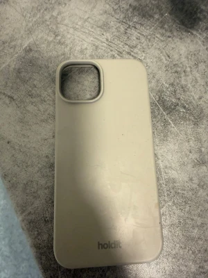Beige mobilskal från Holdit - Snyggt och stilrent mobilskal i beige från Holdit. Skalet är gjort i mjukt silikonmaterial som ger ett bra grepp och skyddar mobilen mot repor och stötar. Passar perfekt för dig som vill ha ett minimalistiskt och modernt utseende på din telefon. till en iphone 14