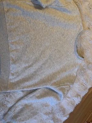 Ljusgrå sweatshirt från 157 - En basic ljusgrå sweatshirt från 157 med rund halsringning och ribbade muddar vid ärmslut och nederkant. Tröjan är tillverkad i mjukt bomullsmaterial och har en avslappnad passform som passar perfekt till jeans eller mjukisbyxor.