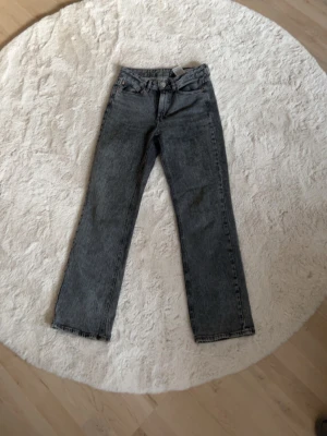 Grå raka jeans - Säljer ett par grå raka jeans med klassisk femficksdesign och hög midja. 