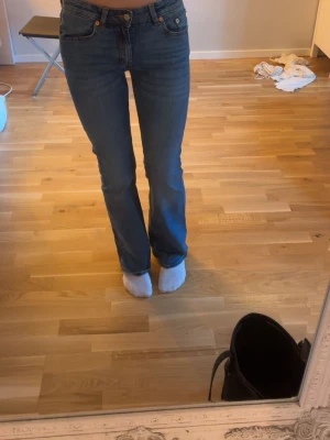 Blå bootcut jeans med mellan midja - Säljer ett par klassiska blå bootcut jeans med mellan midja och fem fickor. Jeansen har en tidlös tvätt och raka ben som går ut lite nedtill. Perfekta till vardags och lätta att matcha med olika stilar. Materialet är denim i bomull. Kommer ej till användning, tvättas innan jag skickar dom💖