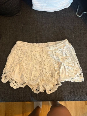 lågmidjade crèmefärgade spets shorts   -  jättefina lågmidjade spetsshorts köpta i utlandet så står ingen storlek 