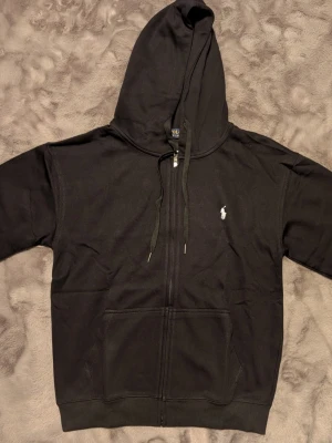 Svart hoodie från Polo Ralph Lauren - Svart hoodie med dragkedja från Polo Ralph Lauren. Storlek M/L