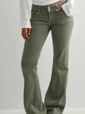 Gröna jeans - Snygga olivgröna bootcut jeans med låg midja och klassisk femficksdesign. Jeansen har vida ben och stängs med knapp och dragkedja. Perfekta för en trendig och avslappnad look.