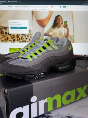 Nike Air Max 95 Neon Grå/Neon - Nike Air Max 95 sneakers i grått med neonfärgade detaljer och svarta inslag. Skorna har synliga Air Max-enheter i sulan, mesh och mocka i ovandelen samt klassiska neonfärgade snören och swoosh-logga på sidan. Perfekta för dig som gillar streetwear och vill sticka ut.