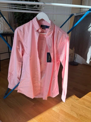 Rosa skjorta från Polo Ralph Lauren - Snygg rosa skjorta från Polo Ralph Lauren i modell slim fitt. Helt ny med prislapp kvar. Ny pris 1895kr mitt pris 1200kr.