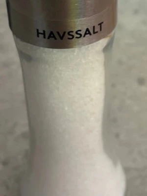 Havssalt i kvarn - En stilren kvarn fylld med vitt havssalt. Kvarnen har en metalltopp med texten 'HAVSSALT' och en genomskinlig kropp så att man ser saltet inuti. Perfekt till matlagning och bordet.