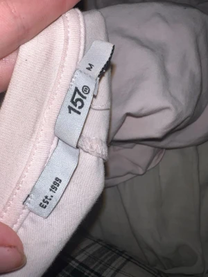 Ljusrosa långärmad topp lager 157 - Ljusrosa långärmad topp från 157. Enkel och stilren design med rund halsringning och mjukt material som känns skönt mot huden. Perfekt att matcha med jeans eller kjol för en avslappnad look.