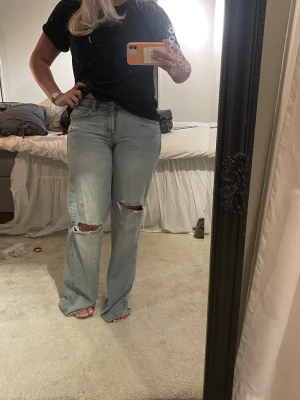 Ljusblå low waist jeans från Zara - Ljusblå jeans från Zara med raka ben och slitningar vid knäna. Jeansen har låg midja och är i storlek 36. 