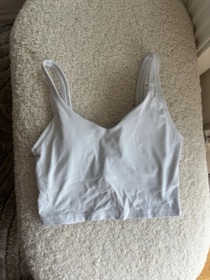 Vit sport-bh från Relode - Säljer en vit sport-bh från Relode med breda axelband och utan vaddering. Bh:n har en enkel, stilren design och är tillverkad i ett stretchigt material som ger bra stöd. Perfekt för träning eller som bekväm vardags-bh.