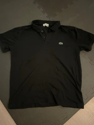 Svart pikétröja från Lacoste - Strlk M fint skick 