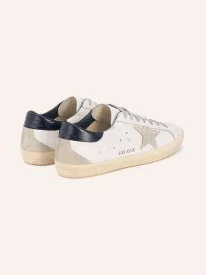 Vita sneakers med grå stjärna - Snygga vita sneakers med grå stjärndetalj på sidan, grå skosnören och mörkblå häl. Ovandelen är i läder och mocka, sulan är beige och har en vintage-look. Perfekta för dig som gillar en avslappnad men trendig stil.
