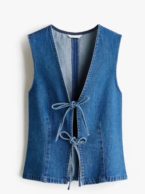 Ärmlös jeansväst med knytband - Snygg ärmlös jeansväst i klassisk blå denim med två knytband framtill. Västen har djup V-ringning och markerade sömmar för en cool vintagekänsla. Perfekt att styla över en t-shirt eller skjorta för en trendig look.