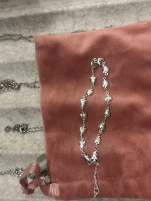 Silverfärgat armband med hjärtan - Säljer ett stilrent armband i silverfärg med små hjärtformade länkar. Armbandet har en tunn kedja och hjärtan som ger en söt och romantisk vibe. Perfekt för dig som gillar detaljer och vill ha något som sticker ut lite extra.