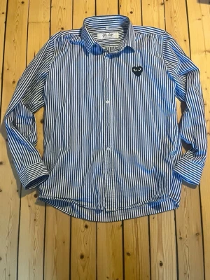 Randig skjorta från Comme des Garçons - Sjukt snygg randig skjorta ifrån Comme des Garçons i blå och vit färg, storlek 4 vilket motsvarar storlek S/M. Skulle säga S. Mycket bra skick. Skriv vid eventuella funderingar😁 