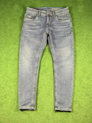 Blå slim fit jeans från Rookies - Snygga blå slim fit jeans från Rookies Jeans Co. med klassisk femficksdesign och kontrastsömmar. Jeansen har en något tvättad look och är tillverkade i mjuk denim som ger en skön passform. Perfekta för dig som gillar en enkel men stilren stil.