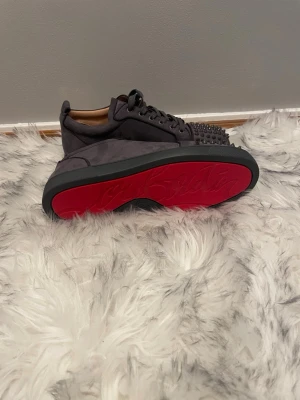 Grå loubs med spikar - Säljer ett par mörk grå loubs med spikar bra skick storlek 42 perfekta skor till sommaren eller balen. Skriv vid frågor.