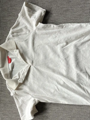 Vit piké t-shirt från Esprit - Klassisk vit piké t-shirt från RYVLS med korta ärmar och krage. Tillverkad i mjuk bomull som känns skön mot huden. Enkel och stilren design som passar till det mesta. Perfekt för dig som gillar en clean och avslappnad look.