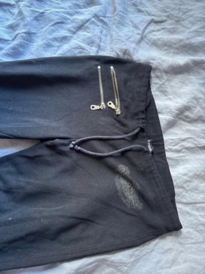 Svarta mjukis byxor med en cool design  - Super snygga byxor ifrån Brooker i storlek S. Byxorna har en liten defekt som man kan se på sista bilden samt är en av dragkedjorna sönder på framsidan.