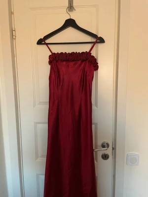 Långklänning, bal, fest, examens klänning - Elegant vinröd långklänning med dekorativ volangdetalj längs överdelen. Passar perfekt till bal, examen, eller fest. Snygg med satinhandskar till!