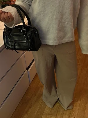 Beiga linnebyxor med raka ben - Snygga beiga linnebyxor med avslappnad passform och raka ben. Byxorna har resår i midjan och två fickor framtill. Perfekta för en chill och stilren look. Tillverkade i linne för en luftig känsla.