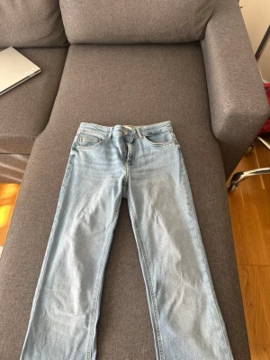 Ljusblå raka jeans från ONLY - Säljer ett par ljusblå jeans från ONLY med klassisk femficksmodell och raka ben. Jeansen har normal midja och är tillverkade i mjukt denimtyg som ger en avslappnad look. Perfekta till vardags och lätta att matcha med olika stilar. Oanvänd helt nya