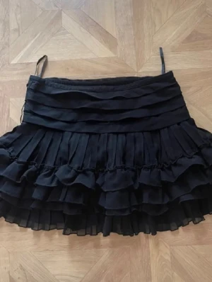 Lågmidjad volangkjol  - Lågmidjad svart volangkjol. Bra skick, inga defekter. Så himla fin och perfekt till sommaren! 
