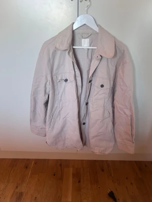 Beige overshirt med fickor - Beige/ljus råsa oversized jacka med lite jeans liknande material. Säljer för att den inte kommer till användning tyvärr. Perfekt till våren.