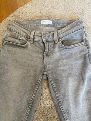 Väldigt lowrised jeans från Ginatricot  - Snygga grå jeans från Ginatricot! Jeansen har vita detaljer på bakfickorna. De är uppsprättade nertill vilket gör att de är lite längre och något ”fransiga” längst ner 💗 Jag säljer dem eftersom att de är för små för mig. I väldigt bra skick annars💗 