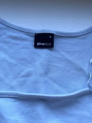 Ljusblå topp från Gina Tricot - Säljer en ljusblå topp från Gina Tricot med korta ärmar och rund halsringning. Toppen är i mjukt material och har en enkel, clean look som passar till allt. Perfekt att styla med jeans eller kjol för en fräsch vibe.