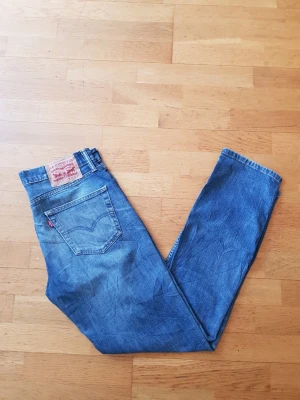 Levi's 511  - Säljer ett par klassiska blå Levi's 511 jeans med rak passform och normal midja. Jeansen har fem fickor, Levi's ikoniska röda etikett på bakfickan och patch med logga i midjan. Tillverkade i slitstark denim av bomull.