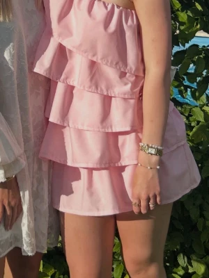 Anielle Ruffle Dress Rosa - Säljer min slutsålda rosa klänning från anielle i S! Den är endast använd 1 gång på midsommar och är som ny. Två laget med tyg så den är ej genomskinlig och det tajta lagret under volangen gör att klänningen sitter bra på kroppen. 