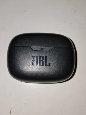 JBL svarta trådlösa in-ear hörlurar (ÄKTA) - Säljer ett par svarta trådlösa in-ear hörlurar från JBL med laddningsetui. Snygg och kompakt design, perfekt för musik och samtal på språng. Hörlurarna har en matt finish och etuiet är robust och smidigt att ta med sig.