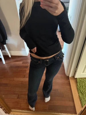 True Religion mörkblå bootcut jeans - Säljer ett par mörkblå jeans från True Religion💗Pris går att diskutera!💕Passar som S på en längre person (Är 166cm) Använt 2 gånger finns lite slitningar längs ner (se bild 5) men annars så ser dom helt nya ut!🩷