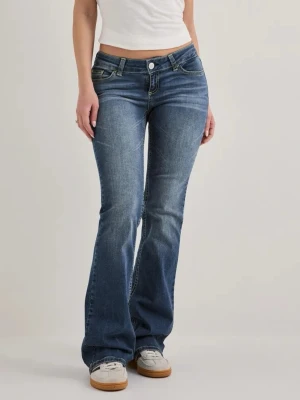 Blå bootcut jeans från Nelly - Säljer ett par blå bootcut jeans från Nelly med låg midja och klassisk femficksdesign. Jeansen har snygga slitningar och kontrastsömmar, tillverkade i stretchigt denimtyg för skön passform. Perfekta för en avslappnad och trendig look.